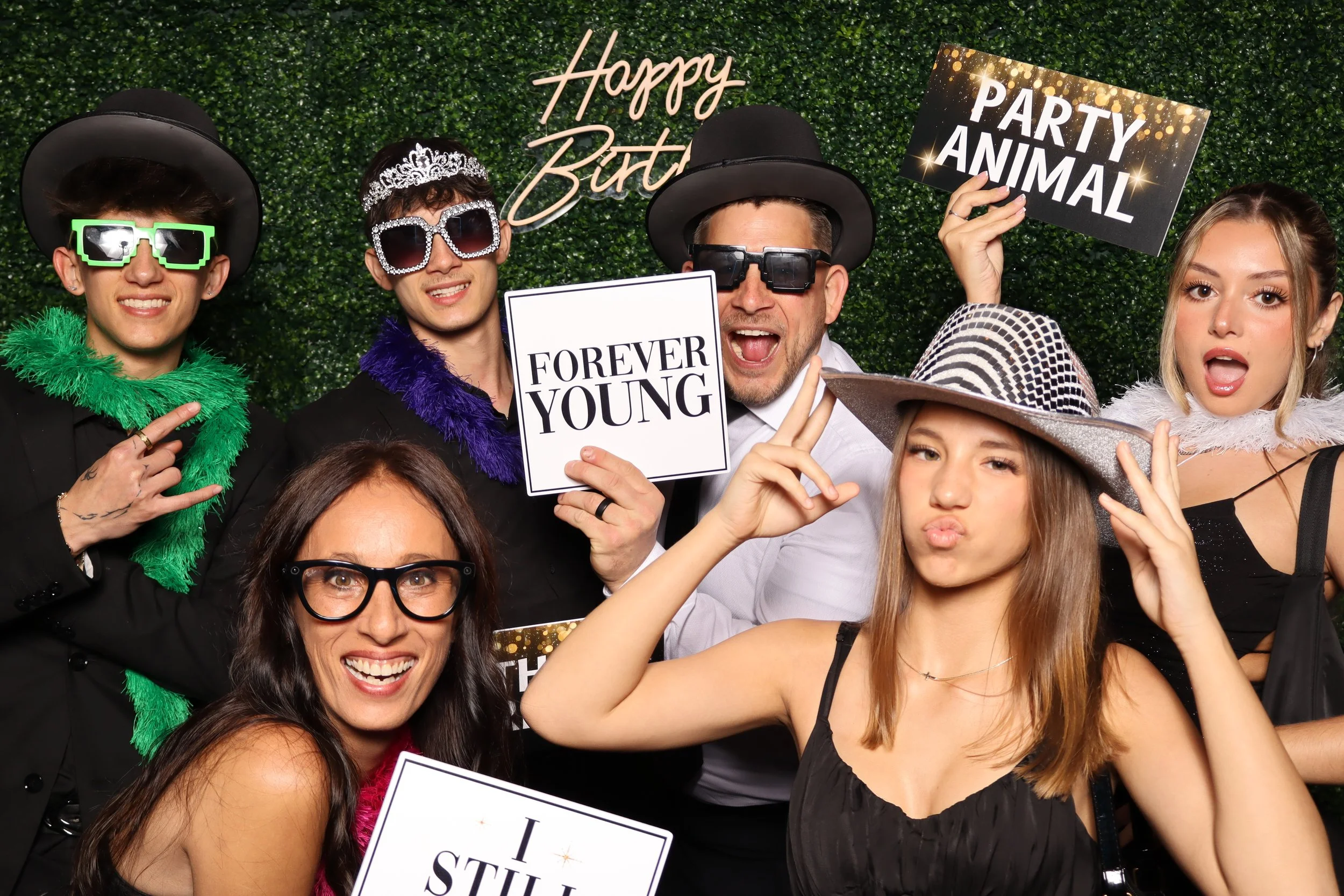 Luxury birthday photo booth experience with green hedge wall and “Happy Birthday” sign at Jacaranda Golf Club in Plantation, FL by AdCole Events