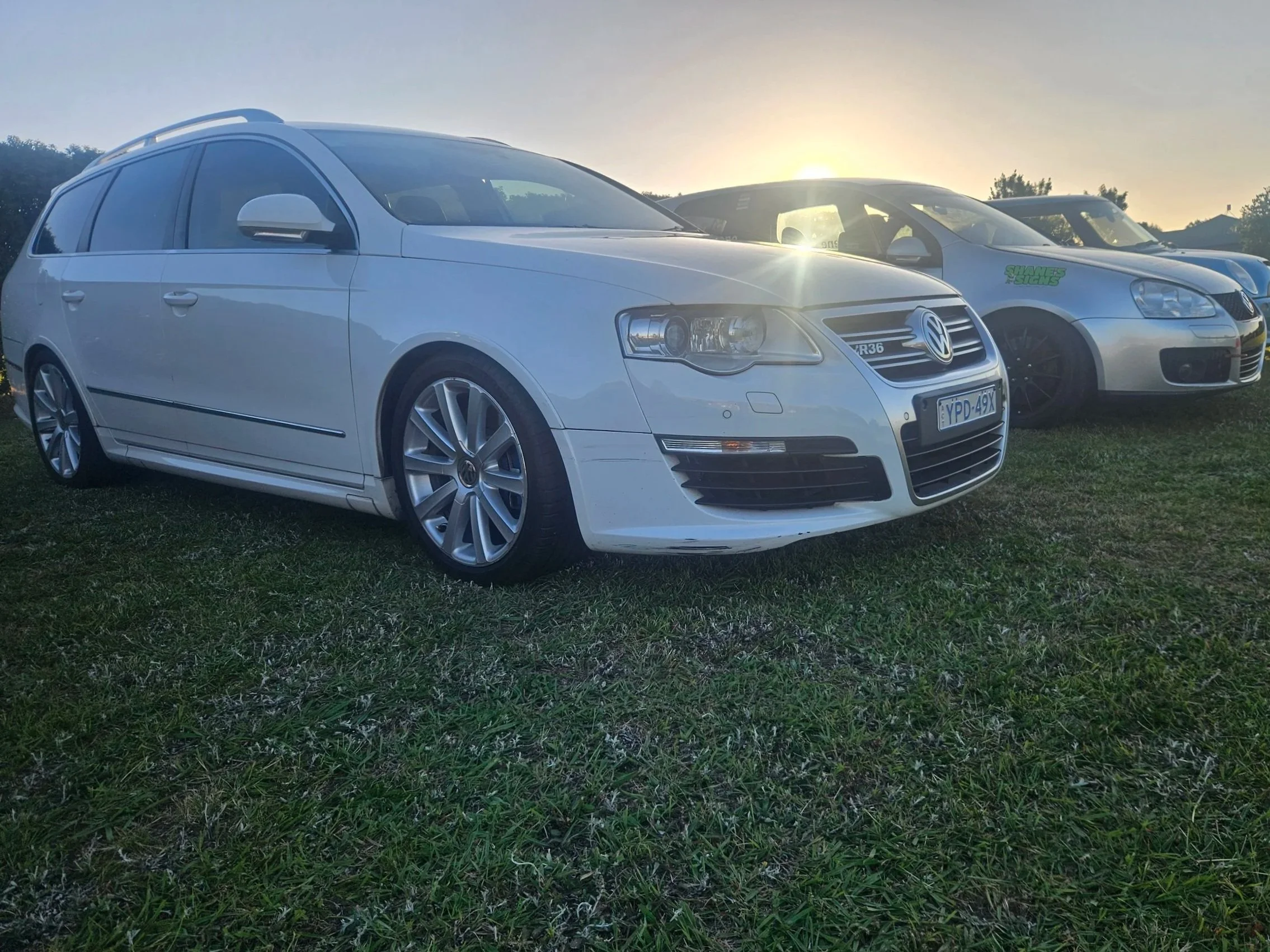 A white Volkswagen Passat station wagon parked on grass at sunset, with other cars and trees in the background.
Stage One Garage / Euro Performance Collectives R36 project.