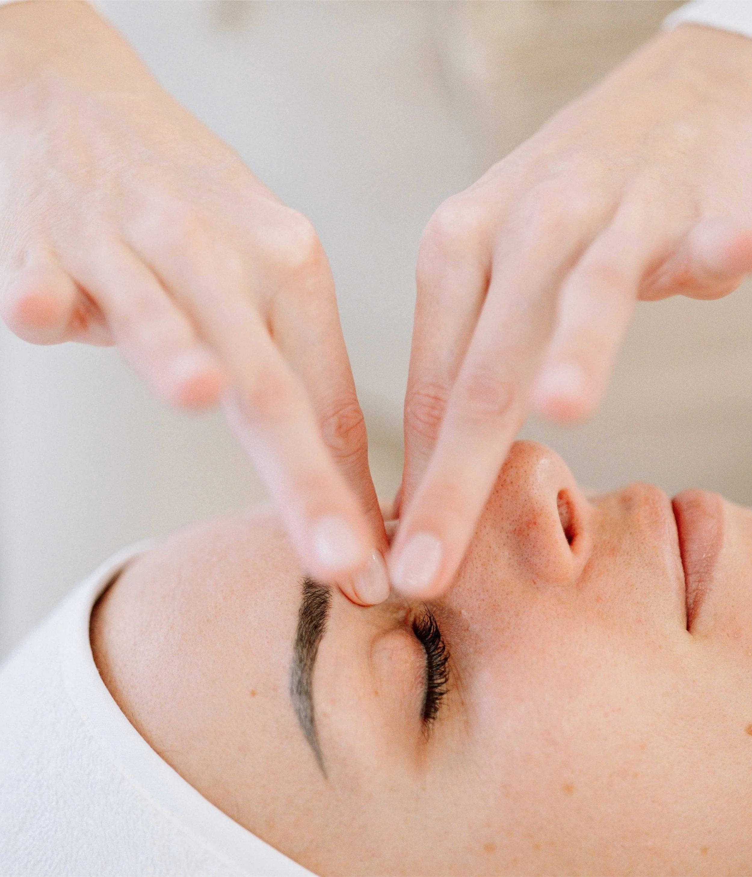 Massage du visage réalisé par une facialiste experte à Nice, avec un geste au niveau du contour de l'oeil.