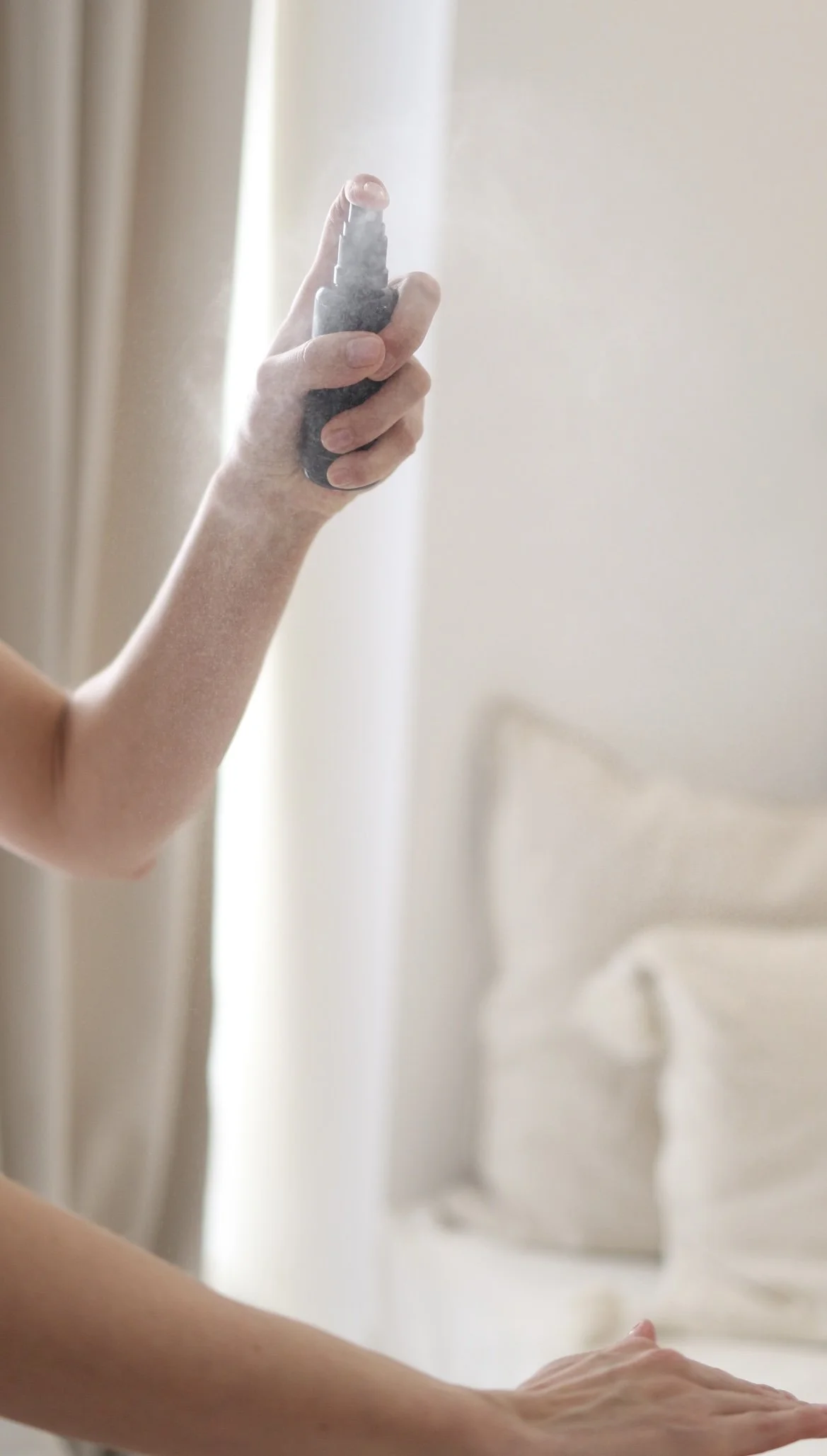 Main vaporisant une brume skincare lors d'un événement presse beauté.