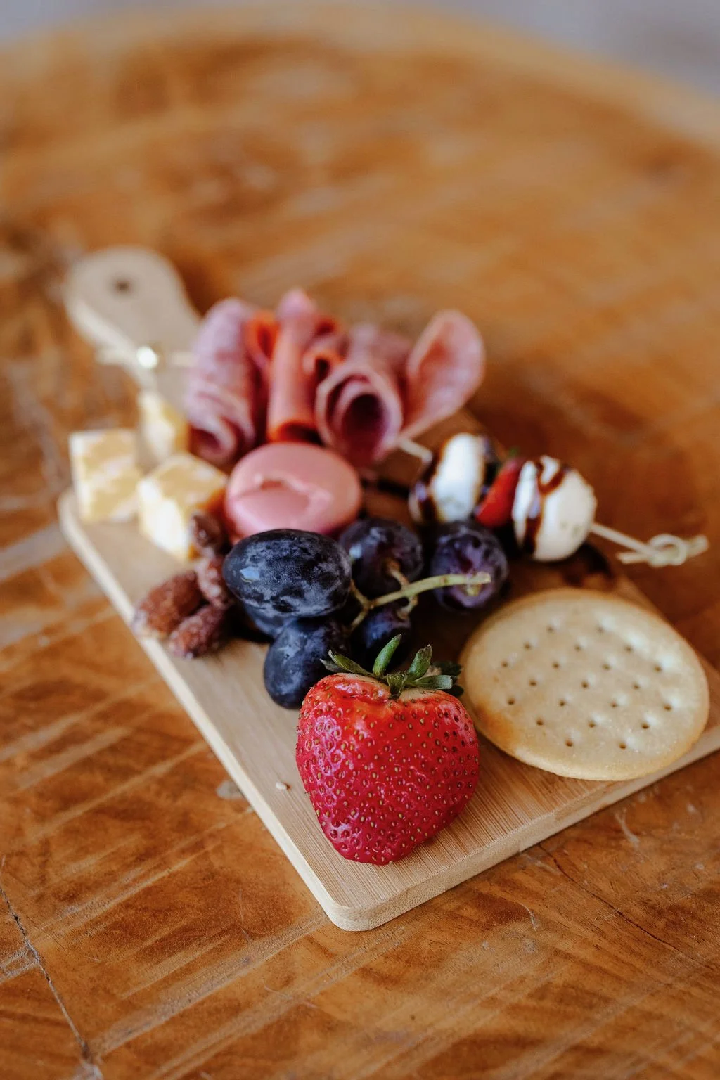 Mini board, cheese, crackers, salami, grapes, strawberry