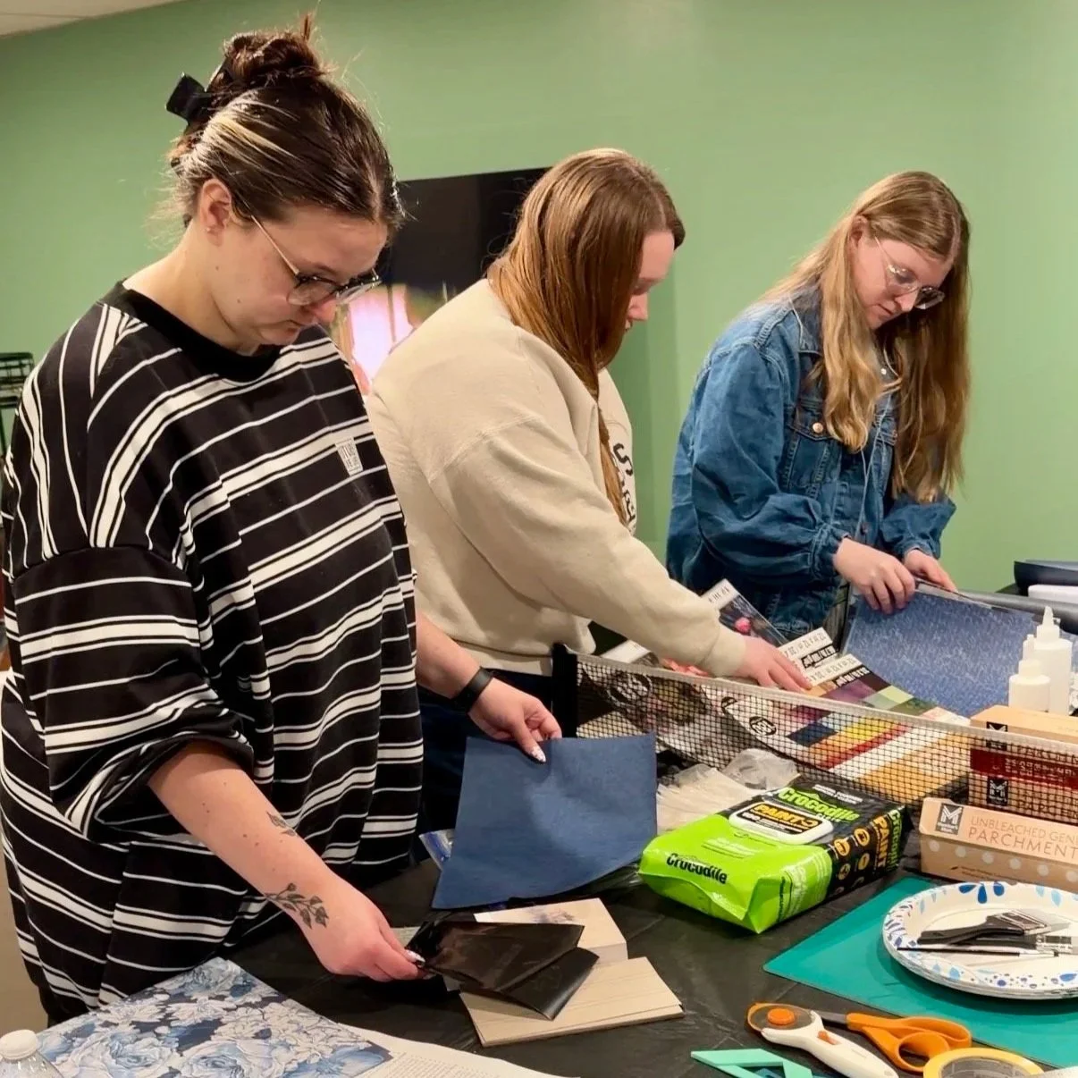 Three friends picking out their bookcloth and endpages to create their own special edition