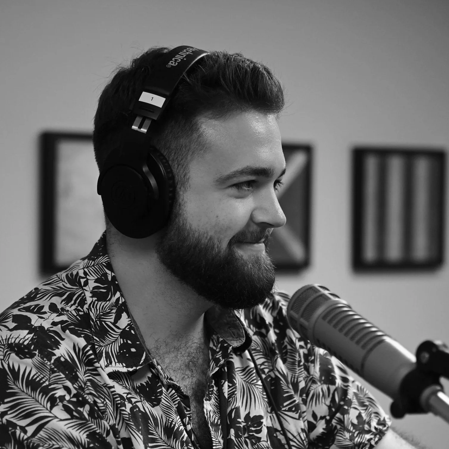 Side profile of Jared Ball in front of a microphone wearing headphones in a radio studio.