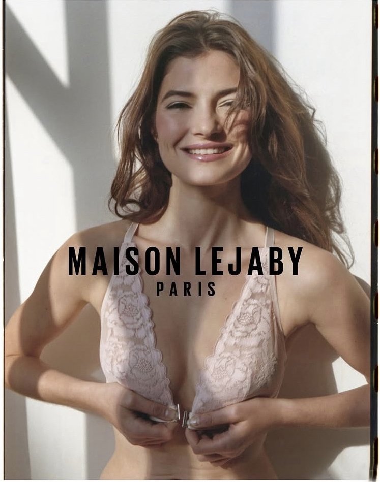 Une femme souriante portant de la lingerie en dentelle, avec le texte "Maison Lejaby Paris" superposé.