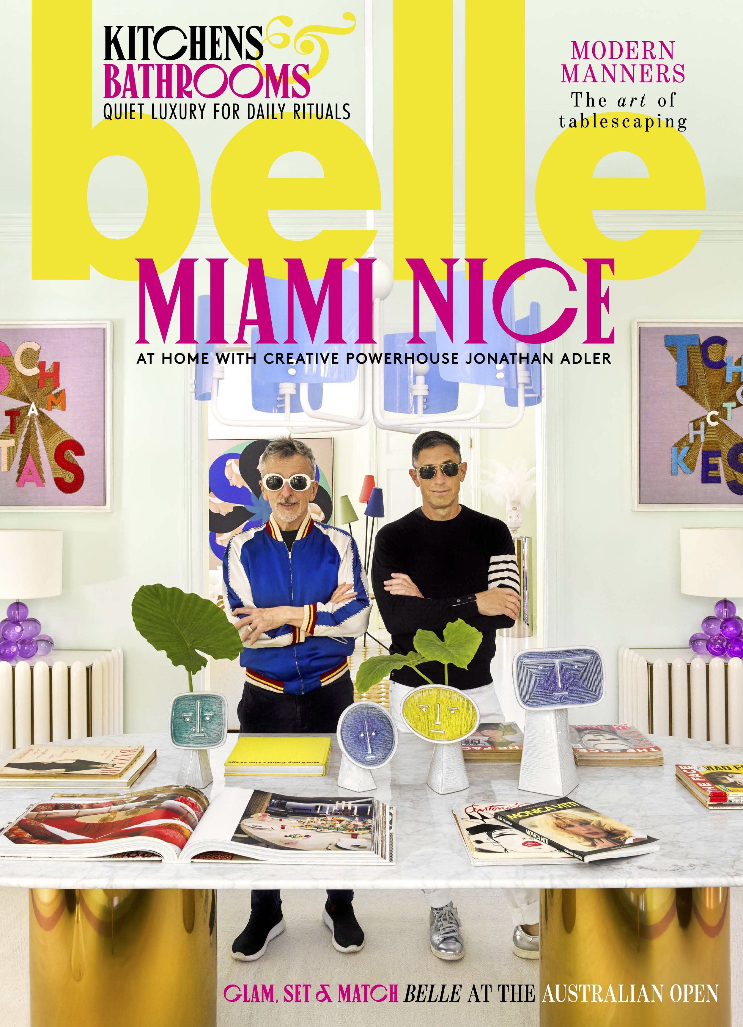 Magazine cover titled 'Kitchens & Bathrooms: Quiet luxury for daily rituals,' featuring two men with sunglasses standing behind a table with decorative items, art on the walls, and bright interior decor.