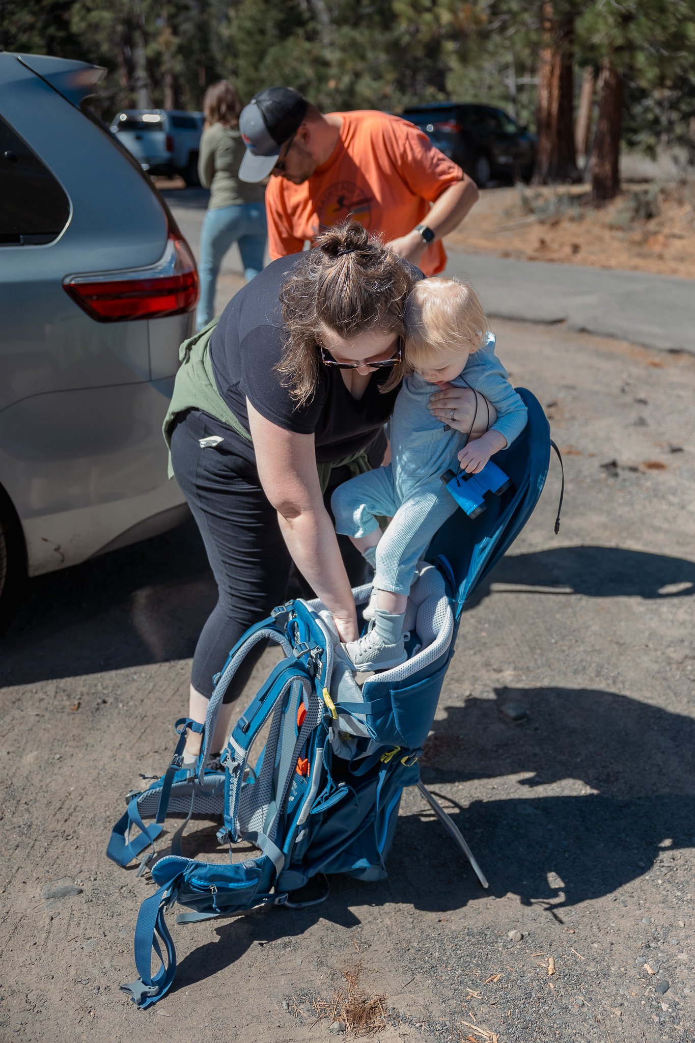 Mom Loading Toddler into Hiking Carrier at Fallen Leaf Lake Parking Lot