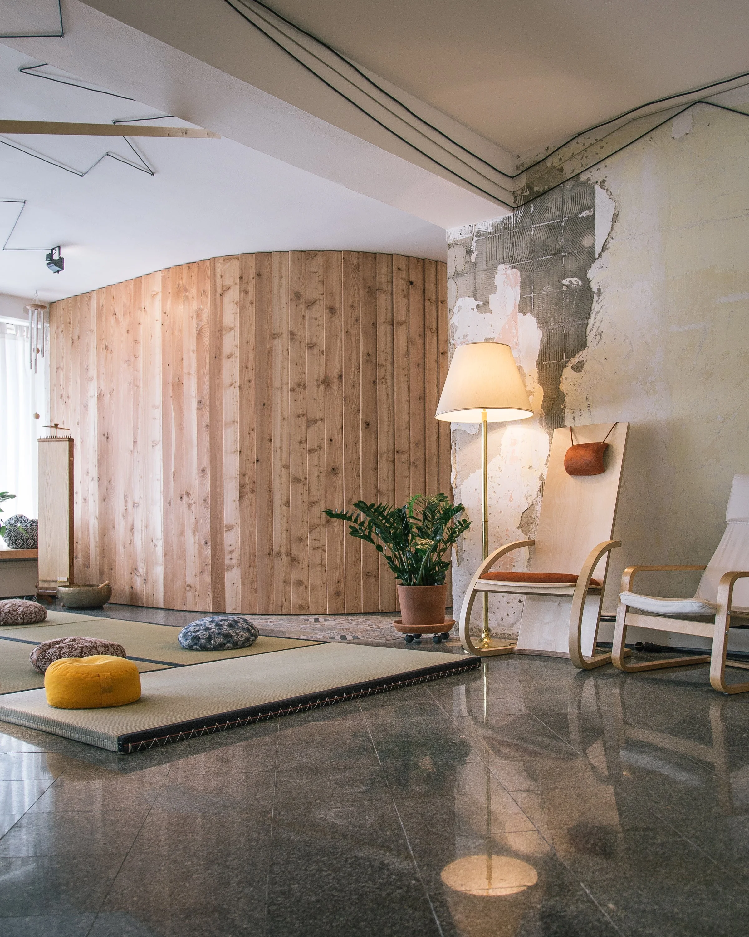 Gemütlicher Veranstaltungsraummit Holzstuhl, Stehlampe, Pflanze und Sitzkissen auf Tatamis (japanische Reismatten); Moderner Einrichtungsstil.