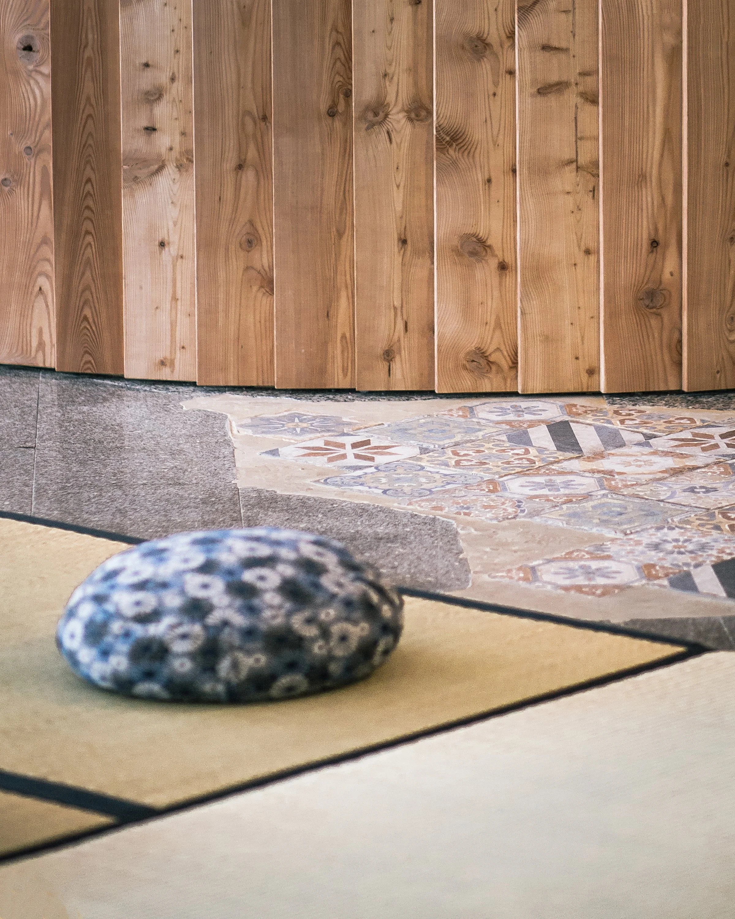 Ausschnitt eines Yogapolsters auf einer Tatami Matte am Boden.