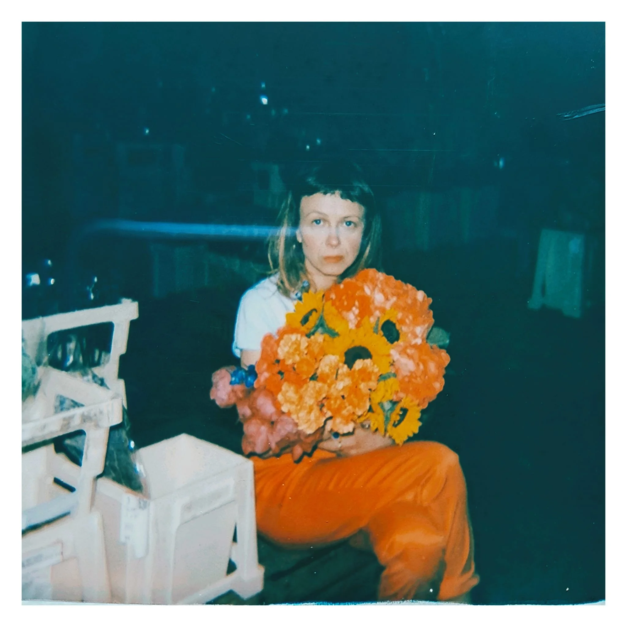 Carla J Easton Album artwork - I Think That I Might Love You.  A woman with shoulder-length hair holding a bouquet of orange and yellow flowers, sitting indoors with a dark background.
