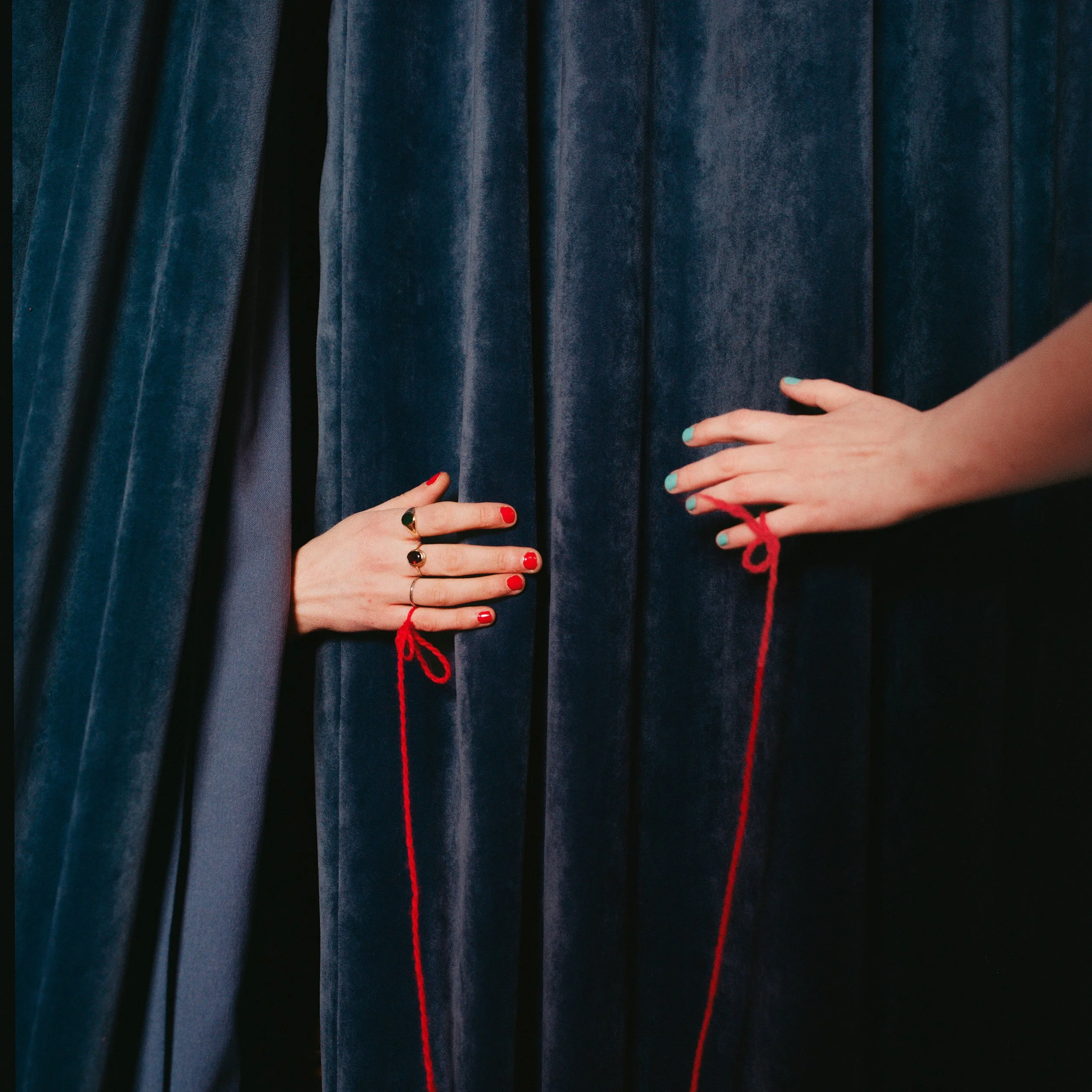 Carla J Easton Album artwork - I Think That I Might Love You Two hands, each with painted nails and rings, holding a red string that is tied to the curtains.