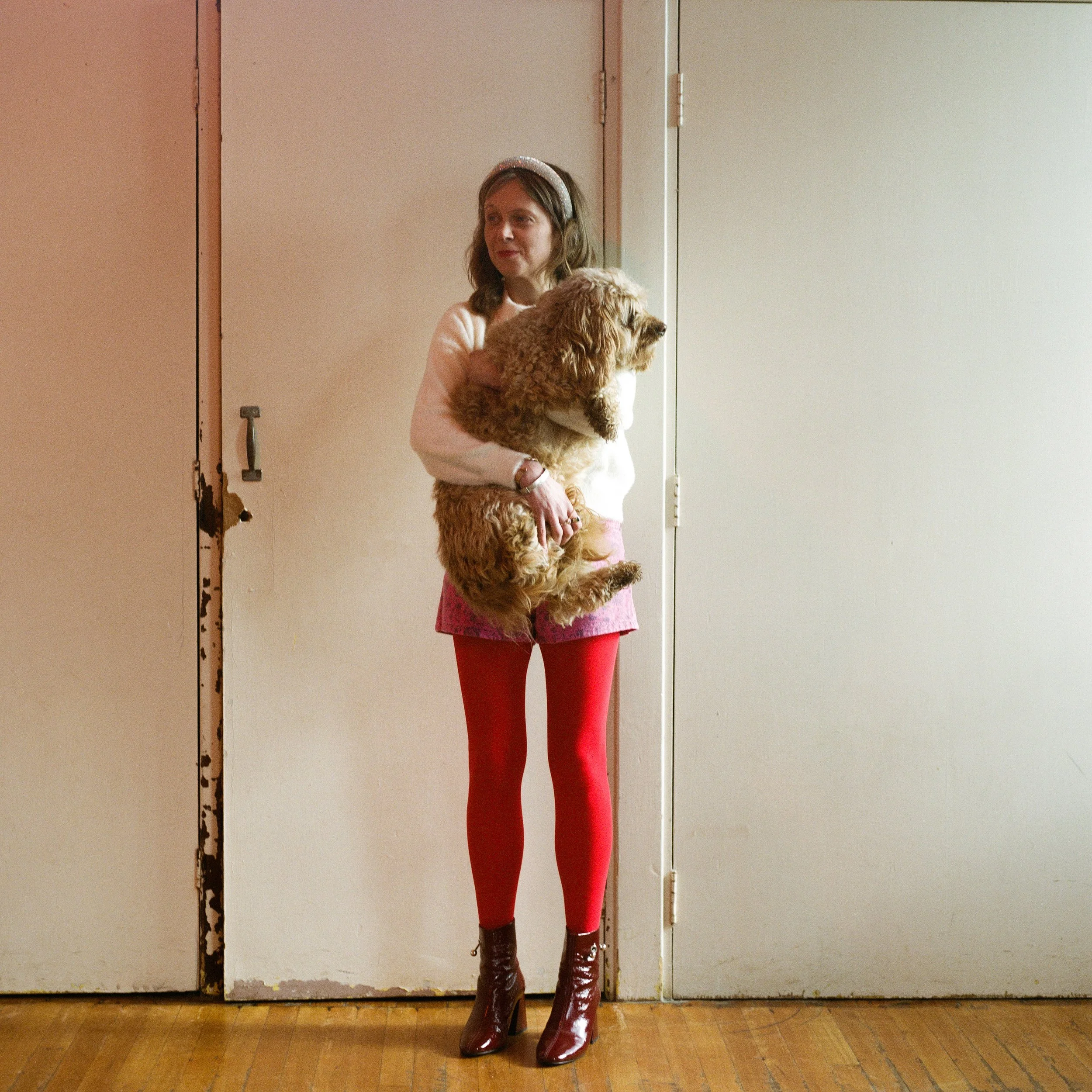 Carla J Easton Album artwork - I Think That I Might Love You A woman standing against a wall holding a curly-haired dog.