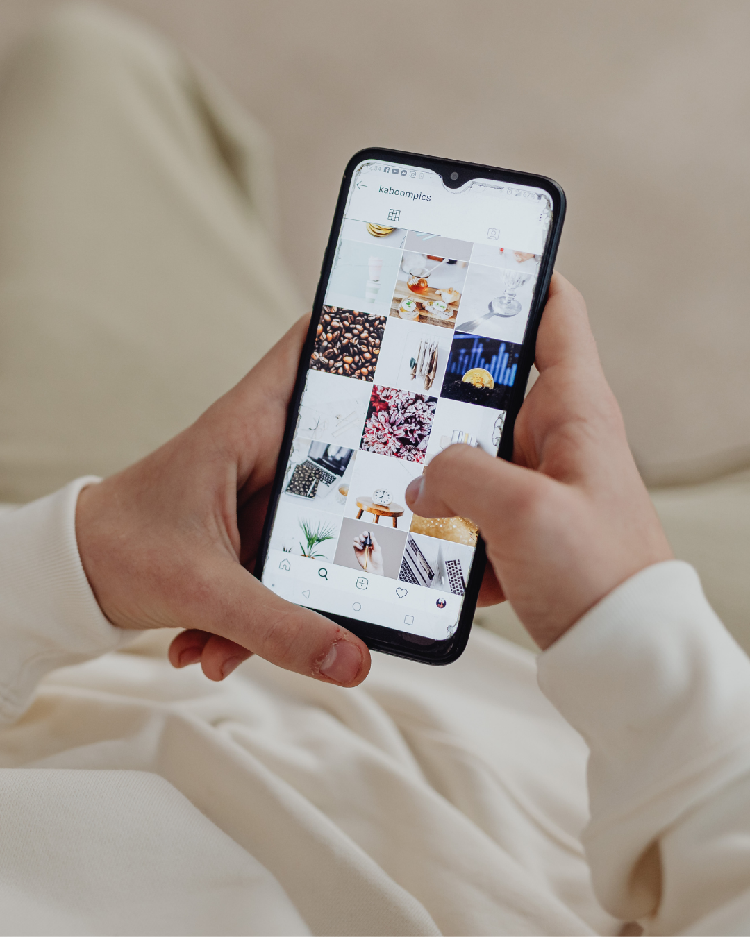 Person holding a smartphone browsing an Instagram page called 'kaboopiccs' with a grid of various images, including food, coffee beans, and plants.