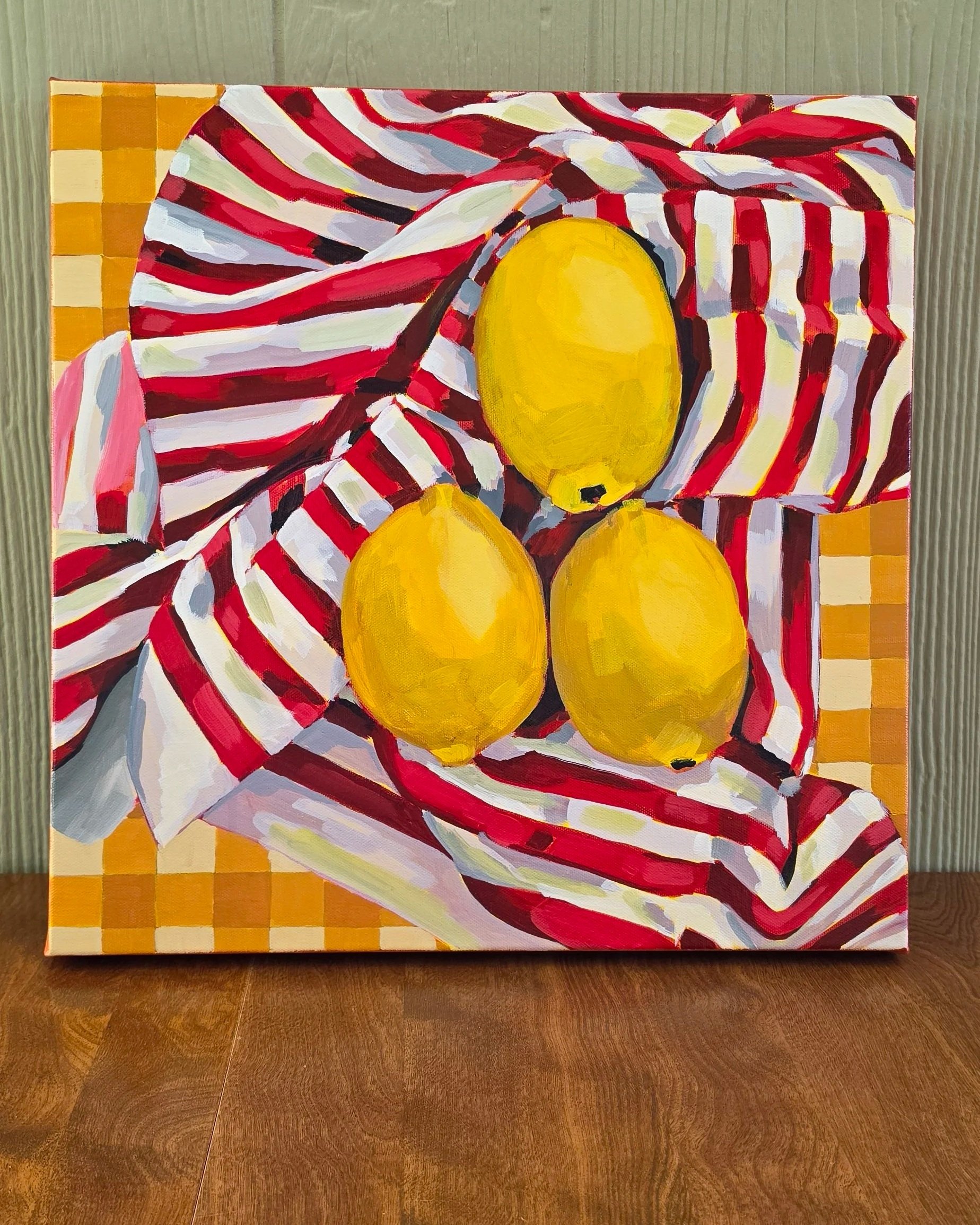 Original acrylic painting of three yellow lemons on a red-and-white striped cloth with warm gingham accents on a 16 × 16 gallery-wrapped canvas by Robin Werner.