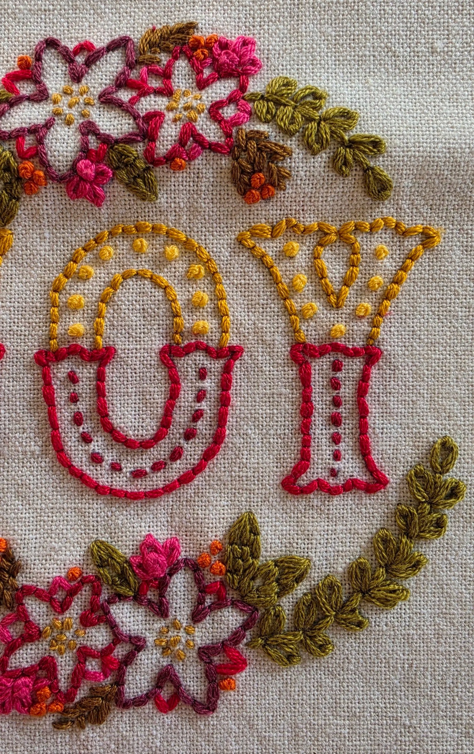 Detailed hand stitching in red and gold thread on the JOY cotton kitchen towel.