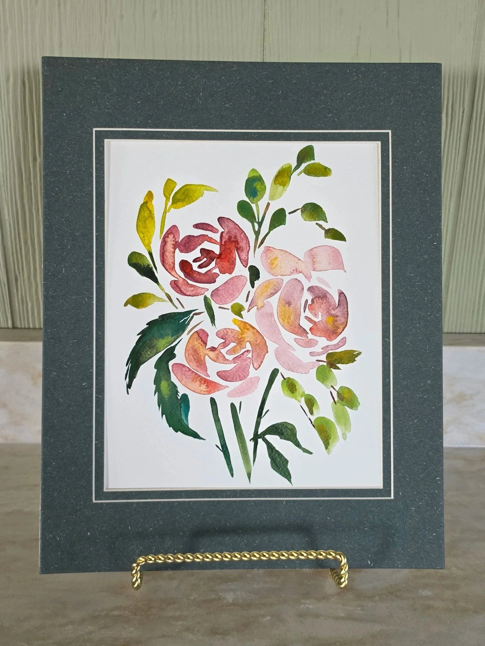 Original floral watercolor painting with soft pink, blush, and peach flowers and green foliage by artist Robin Rae Werner, presented in a green 11×14 double mat.