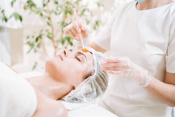 Woman receiving a facial treatment from a professional in a spa or clinic setting.