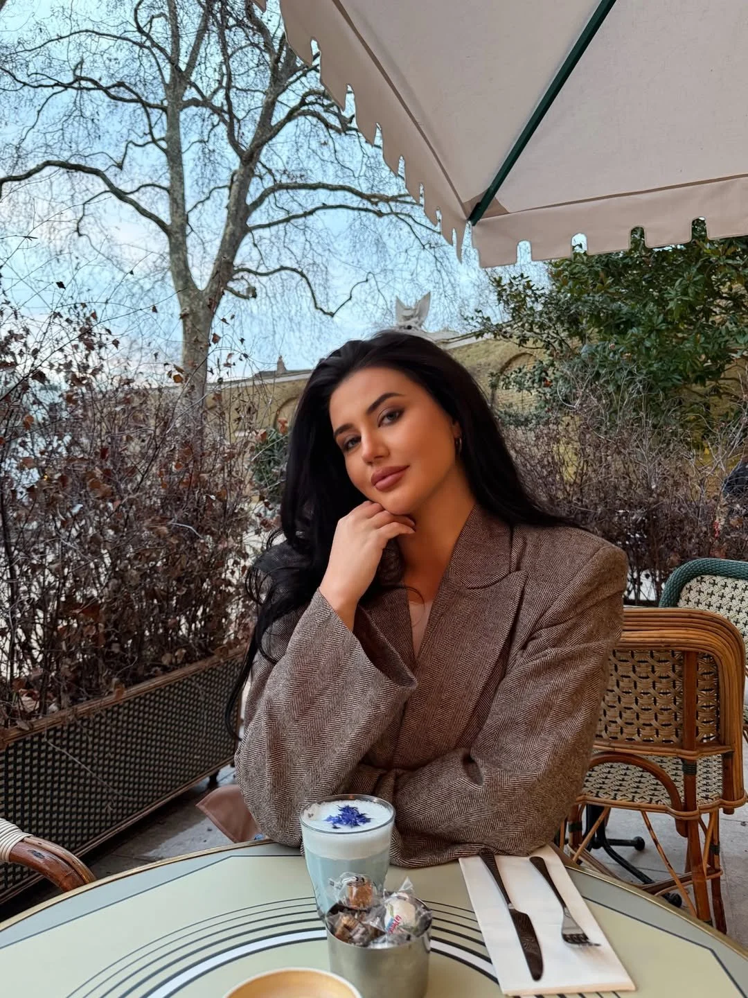 Kyra Skinner, UK lifestyle influencer represented by The New Creative Agency, creating fashion-led content at an outdoor café in Cheshire.
