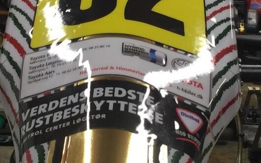 En gokart med etiketter og reklamer på fronten.