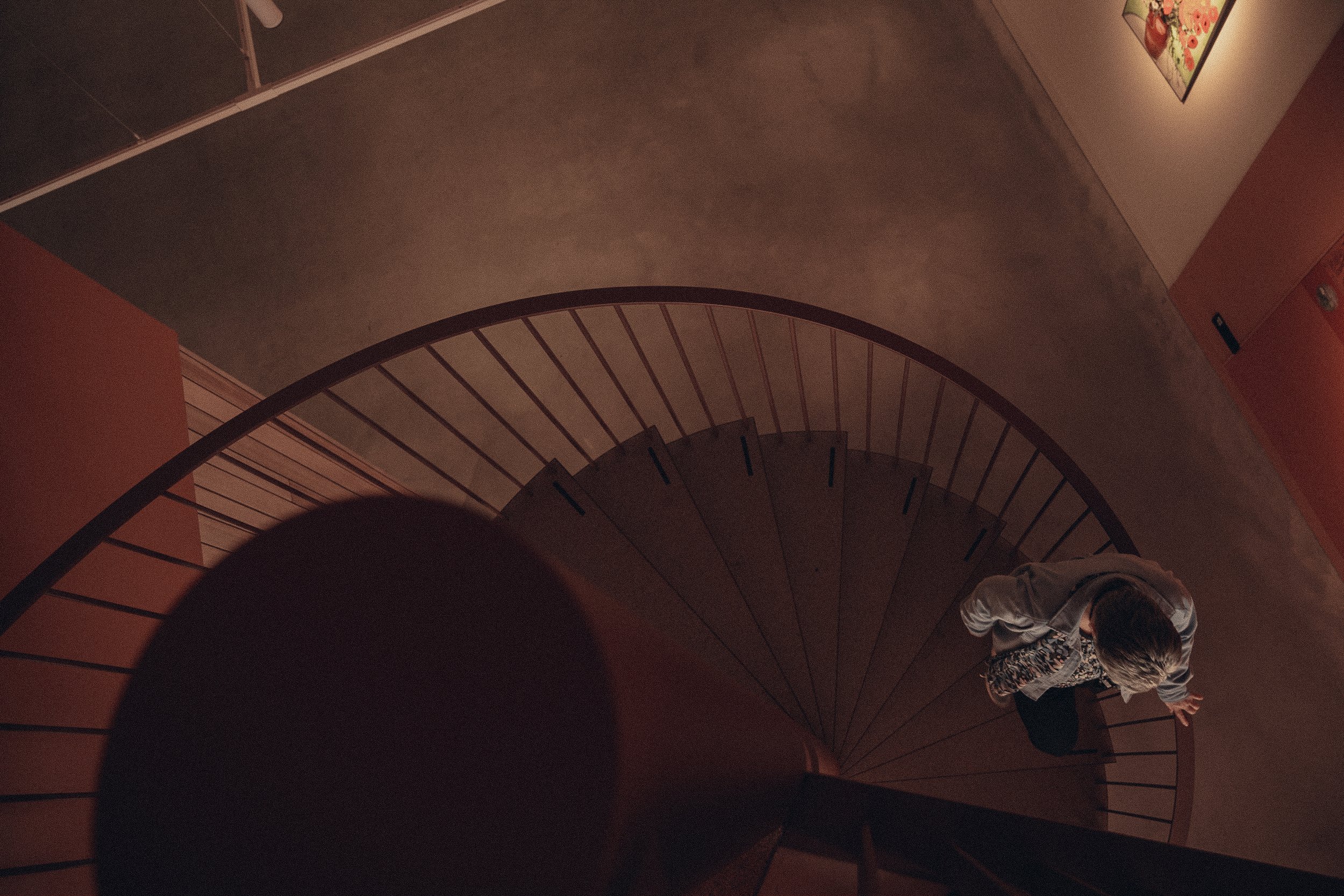 Person walking up a spiral staircase seen from above.