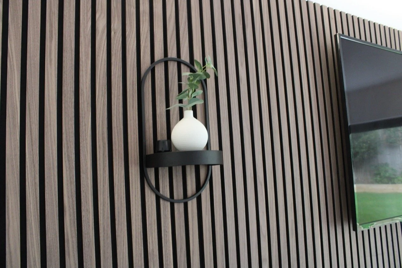 Decorative, modern wall with vertical wooden slats and a mounted flat-screen TV.