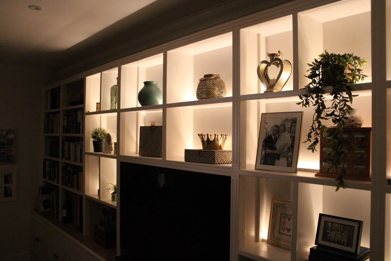 Bespoke media wall in furniture-grade MDF with integrated LED lighting, built-in shelving and concealed TV storage.