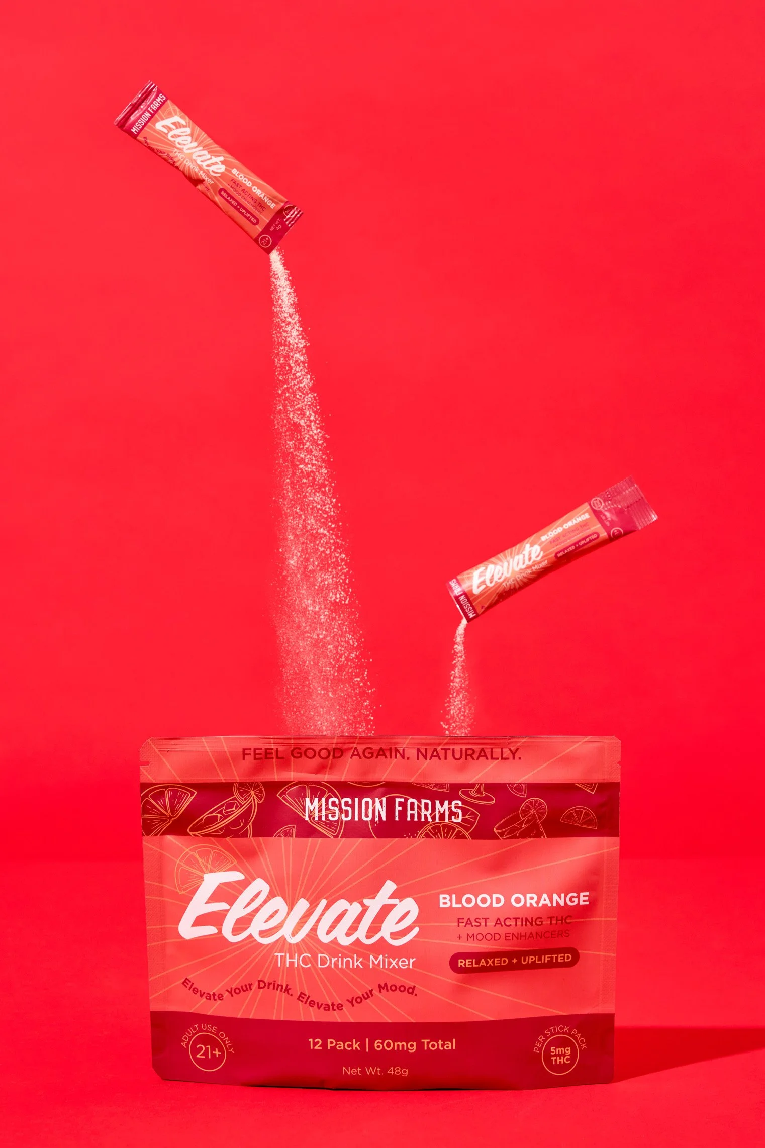 A pink package labeled 'Elevate THC Drink Mixer' with blood orange flavor, showing two individually wrapped packets being poured into the package against a pink background.
