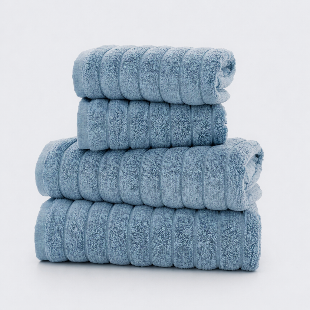 Four folded light blue towels stacked on white background.