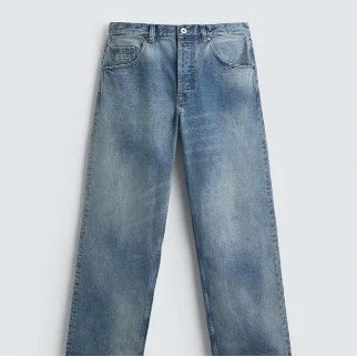 A pair of blue denim jeans laid flat on a light background.