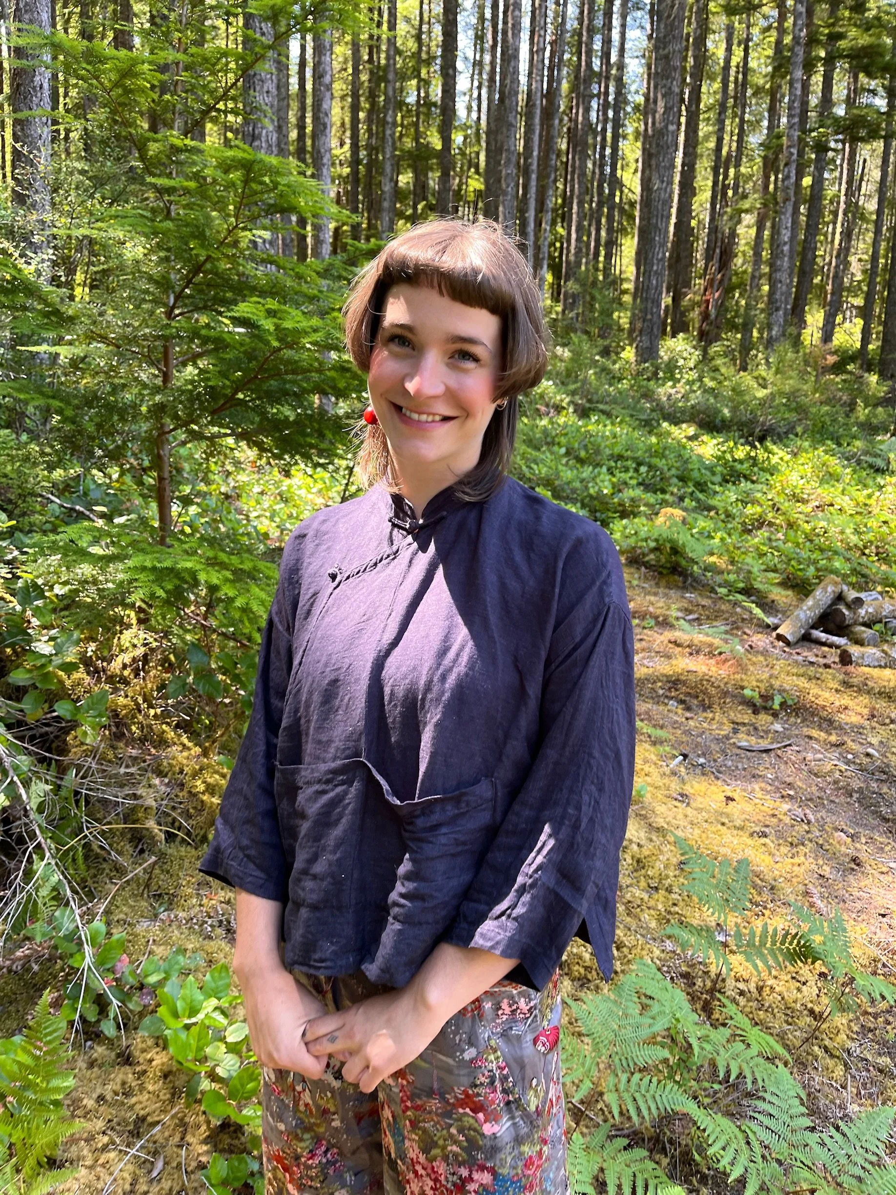 Image of Brooke the Doula standing in the forest in Merville, BC. She is a Doula located in Comox Valley, supporting families with birth and postpartum. Birth and Postpartum Doula located in the Comox Valley.