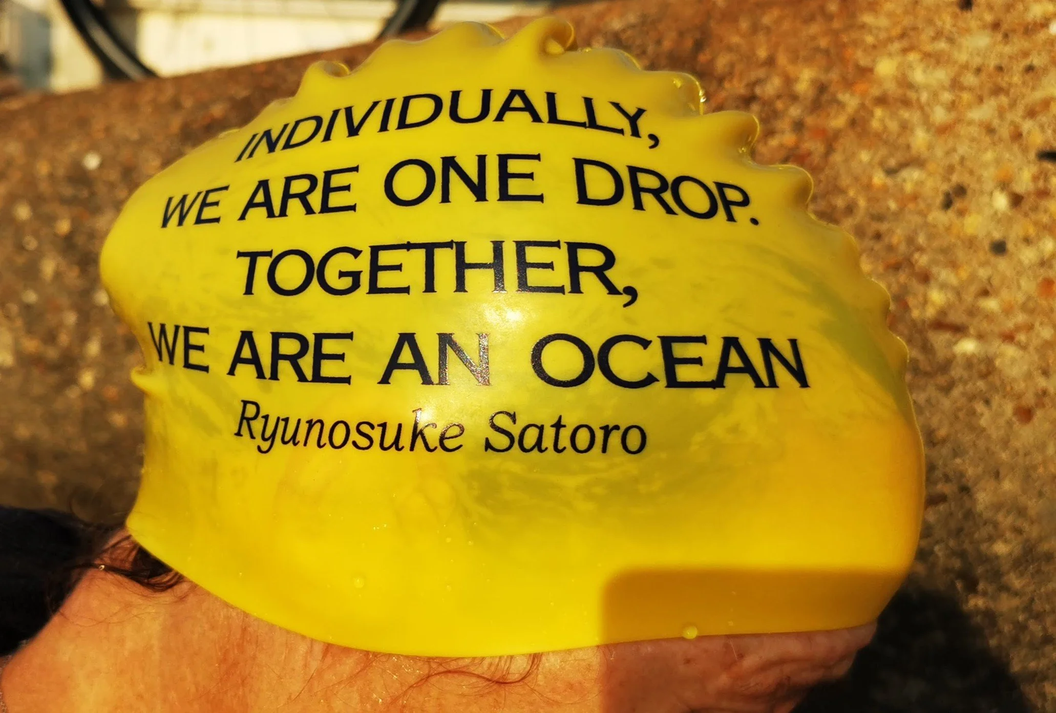 Yellow object with black text that reads, "Individually, we are one drop. Together, we are an ocean" and the name "Ryunosuke Satoro" at the bottom.