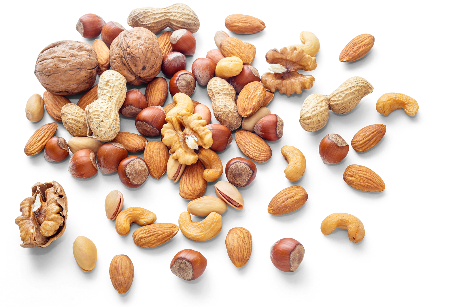 Mixed nuts including walnuts, hazelnuts, almonds, cashews, and peanuts scattered on a surface.