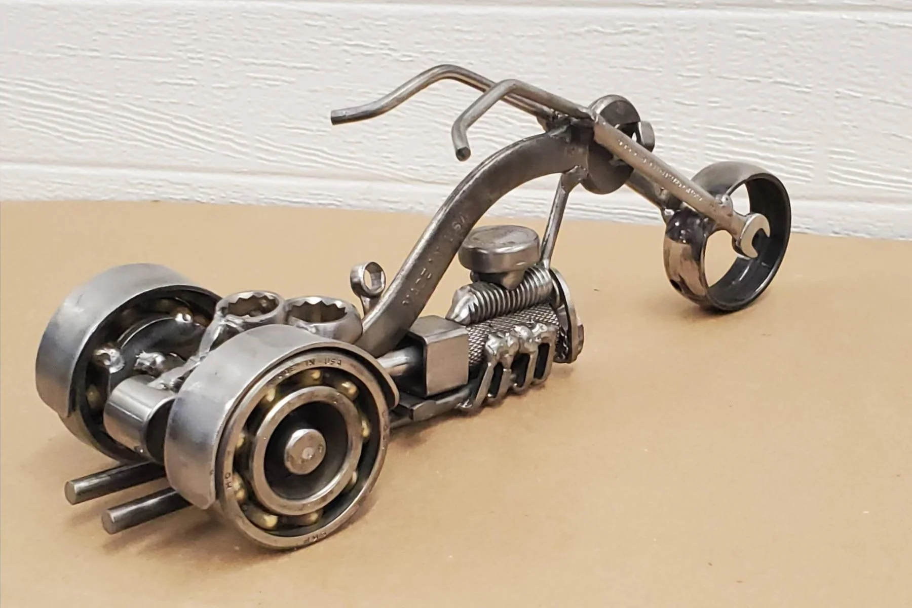 A miniature motorcycle sculpture made from metal mechanical parts.