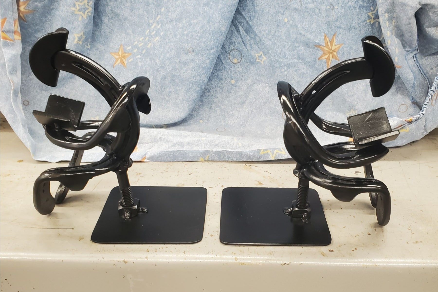 metal sculpture of two people reading on black metal bookends