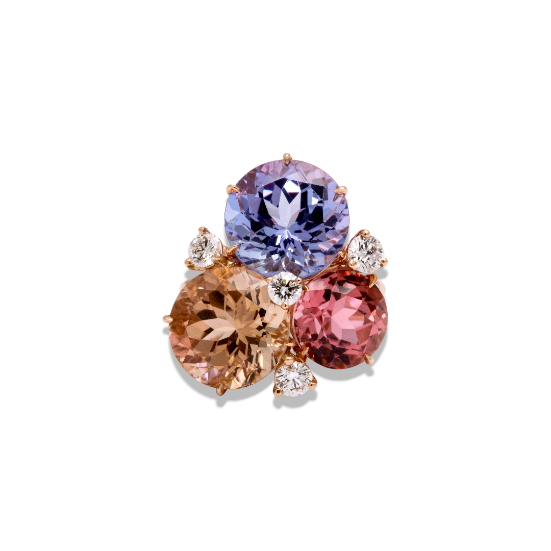 Custom Donna Vock. A colorful gemstone ring with purple, peach, and pink stones accented with small diamonds on a white background.