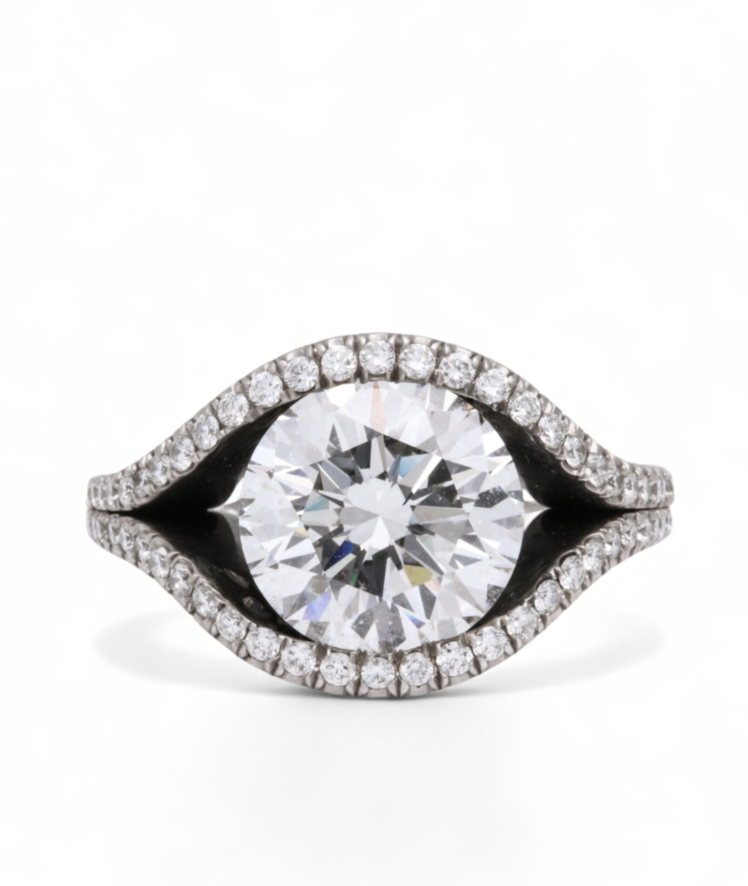 Custom Donna Vock engagement ring. A ring with a large central diamond surrounded by a halo of smaller diamonds on a white background.