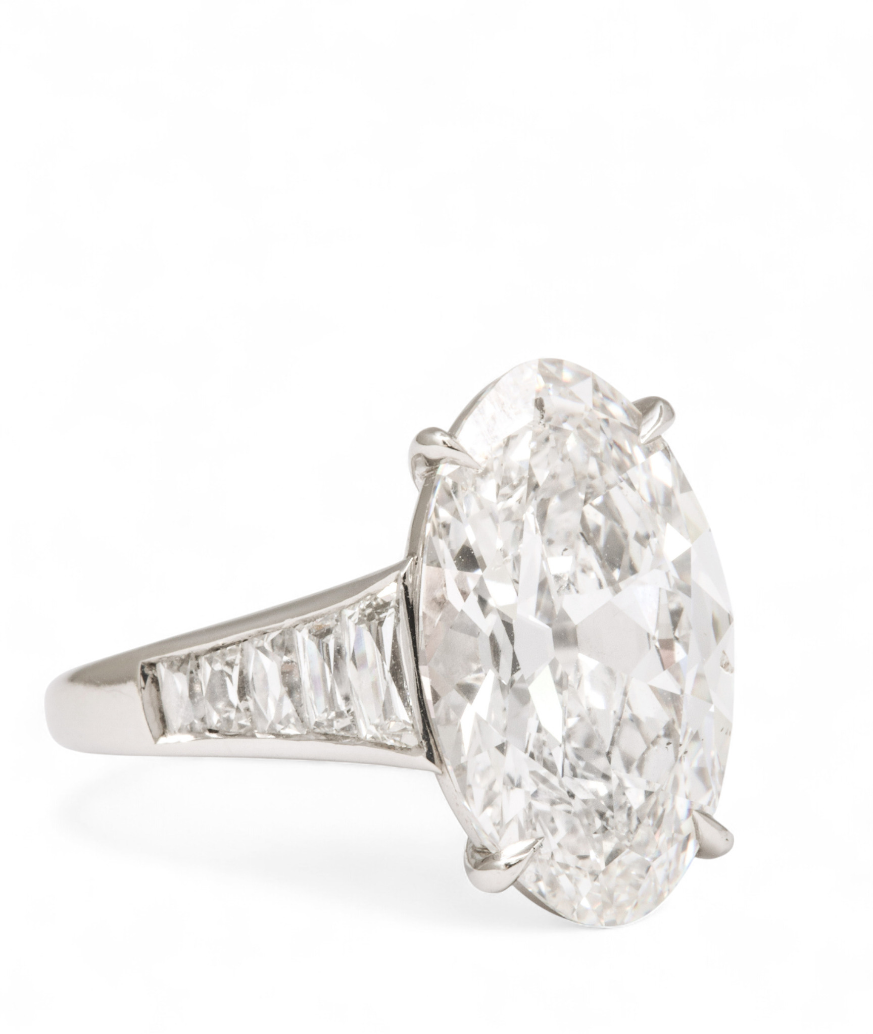 Custom Donna Vock engagement ring. A silver ring with a large oval diamond and smaller diamonds on the band.