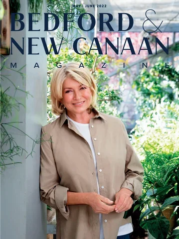 Woman smiling in a greenhouse with lush green plants, on the cover of Bedford & New Canaan Magazine, June 2022 issue.