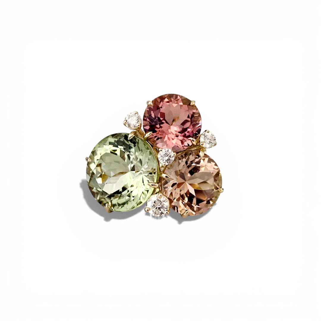 Custom Donna Vock cluster ring. Close-up of a multicolored gemstone ring with pink, green, beige tourmaline and small diamonds accent stones on a white background.