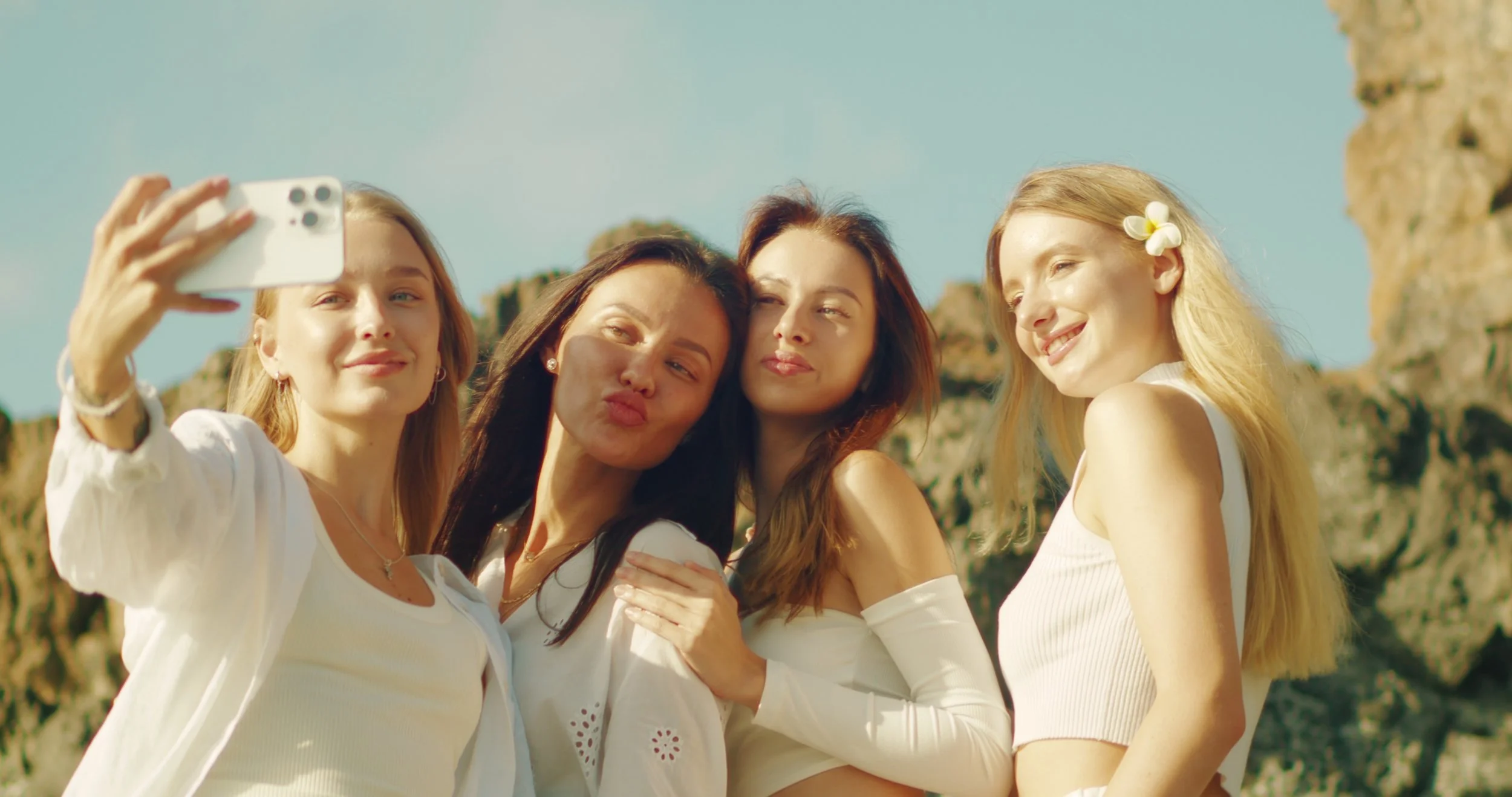 four-women-dressed-in-white-enjoy-a-moment-of-togetherness-while-taking-a-selfie-again-SBI-350138172.jpg