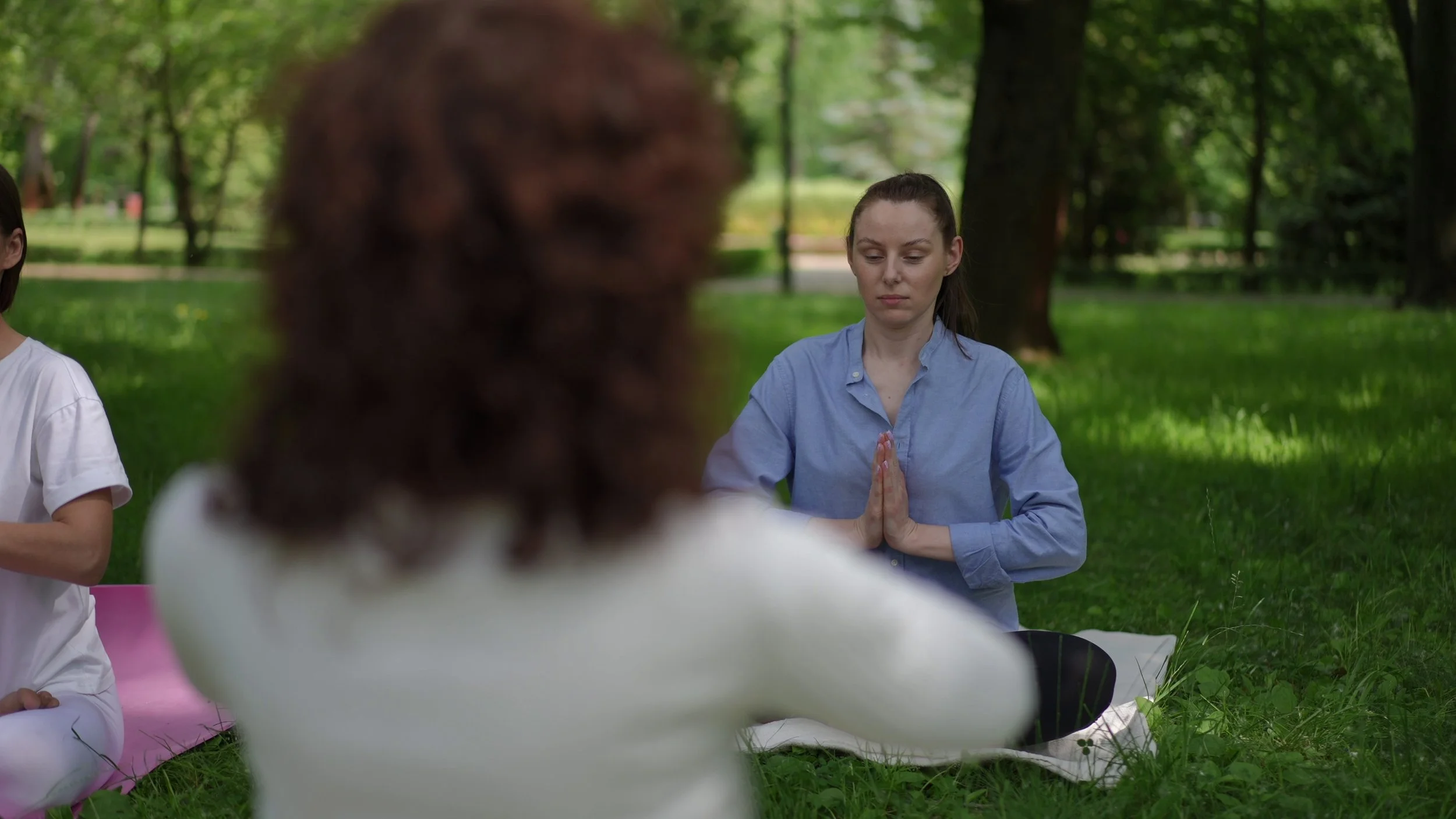 a-yoga-teacher-guides-a-group-of-women-practicing-meditation-and-the-prayer-pose-in-a--SBI-351216942.jpg
