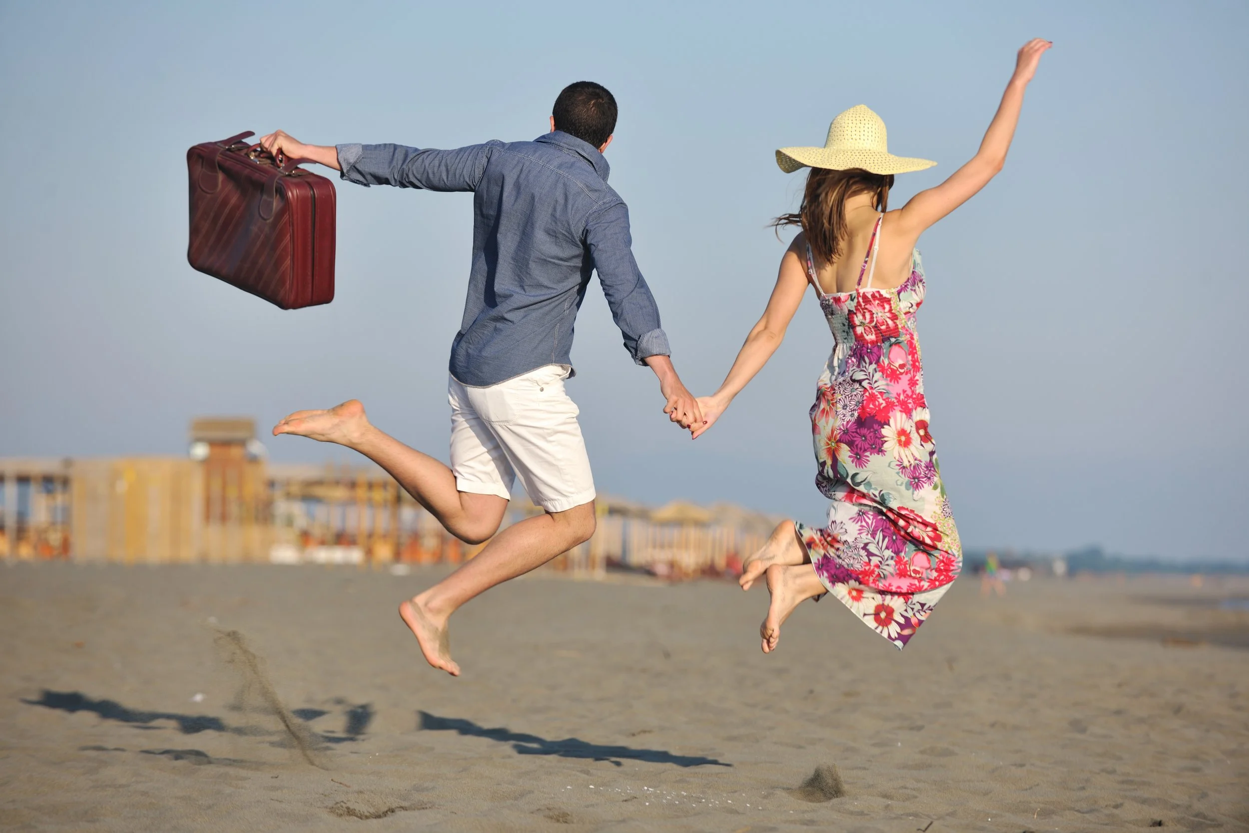 couple-on-beach-with-travel-bag-SBI-300808735.jpg