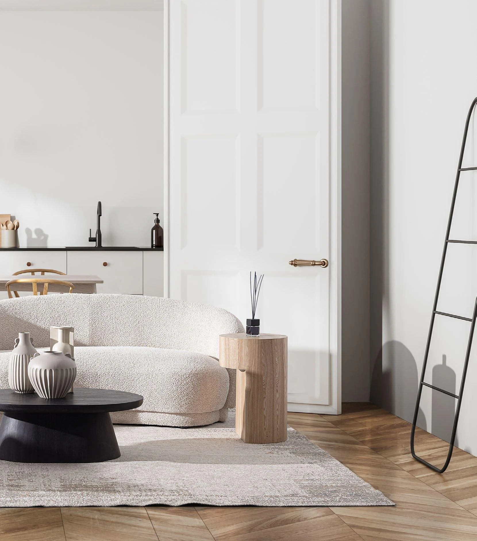 Sala de estar con sofá beige, mesa de centro negra con jarrones blancos, mesita de madera con vaso y varillas aromáticas, piso de madera, pared blanca, puerta y escalera negra decorativa.