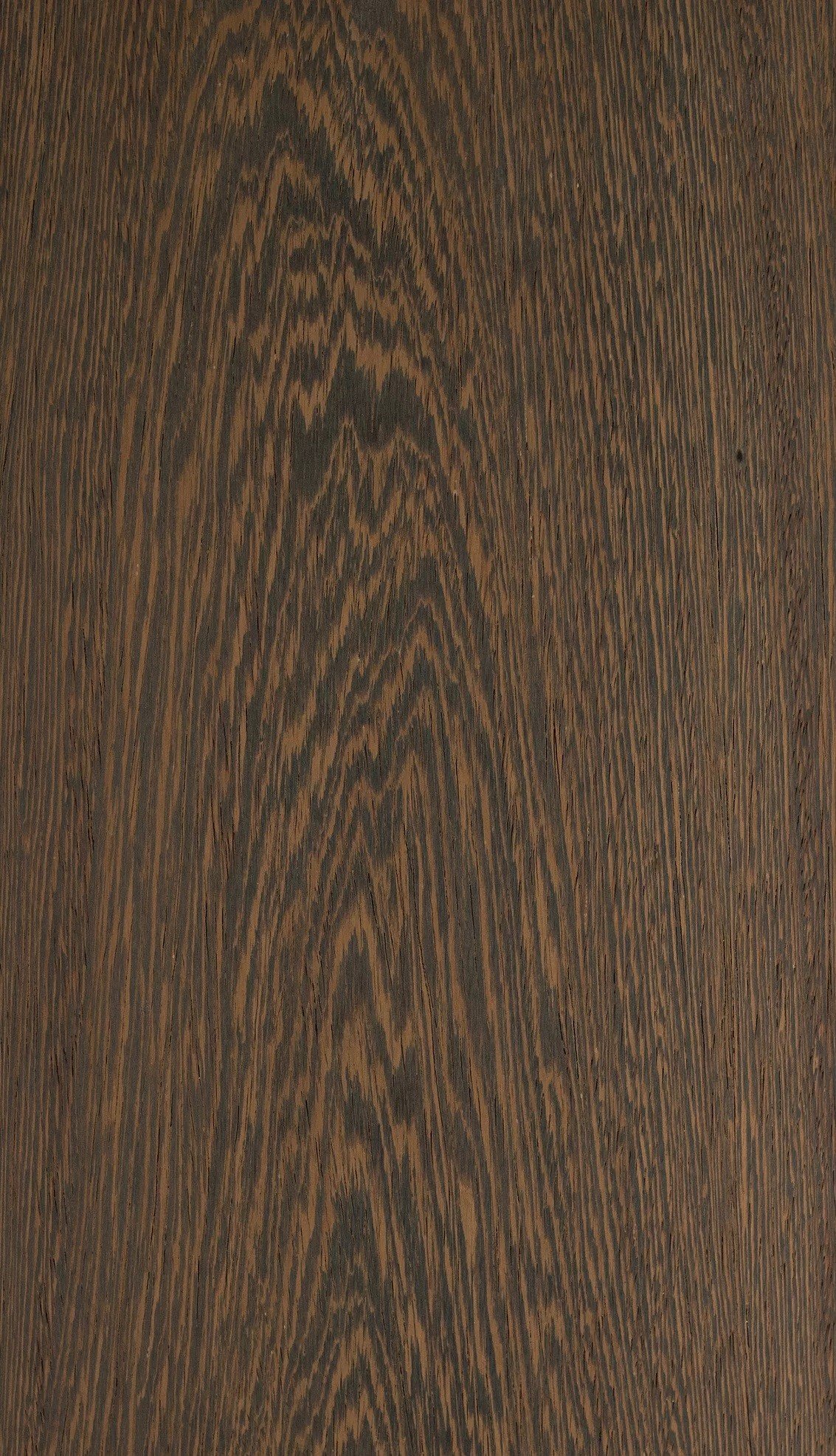 Superficie de madera de color marrón oscuro con vetas y patrones naturales.