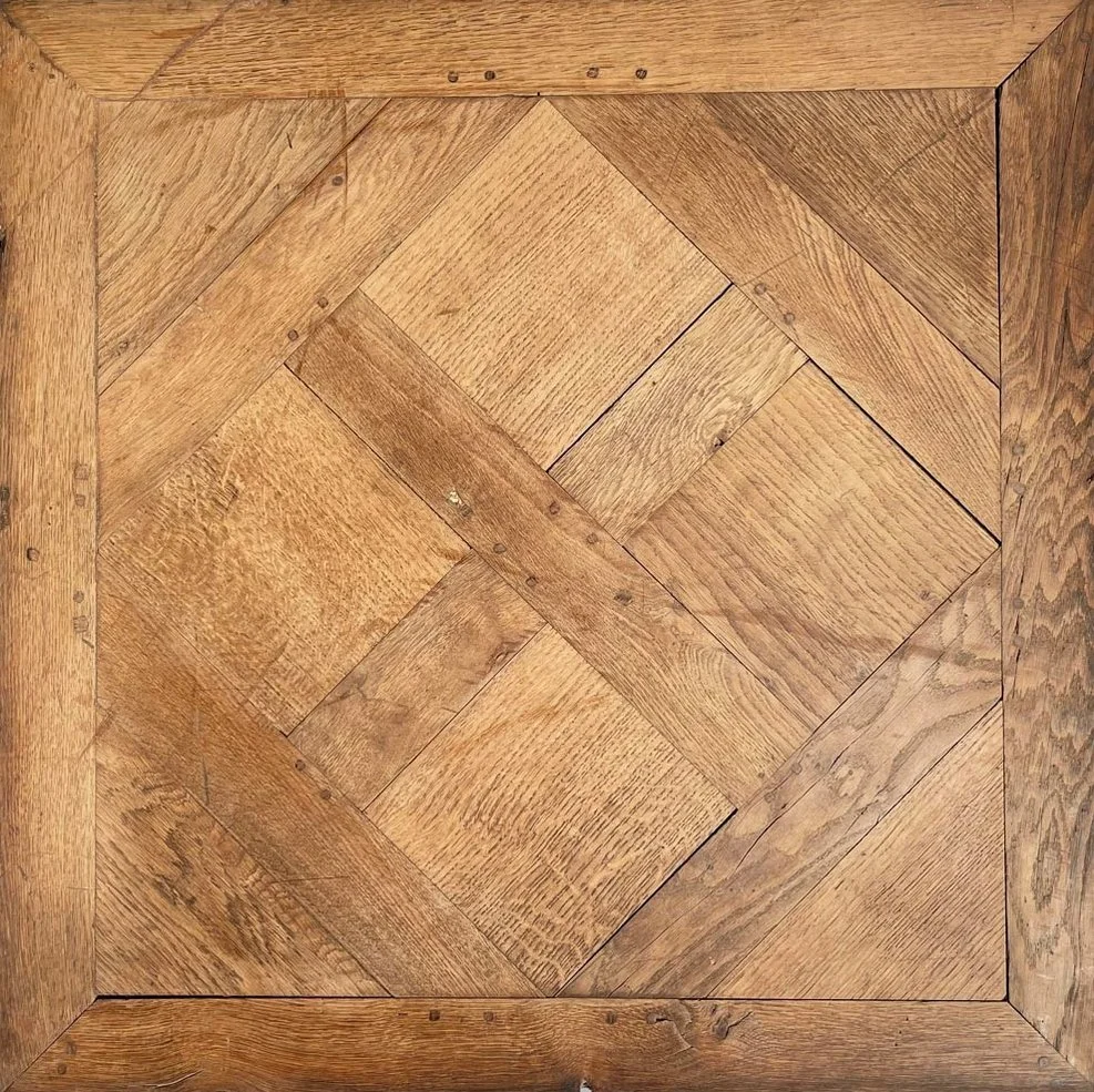 Piso de madera con diseño en espiral formado por tablas de madera en tonos marrones.