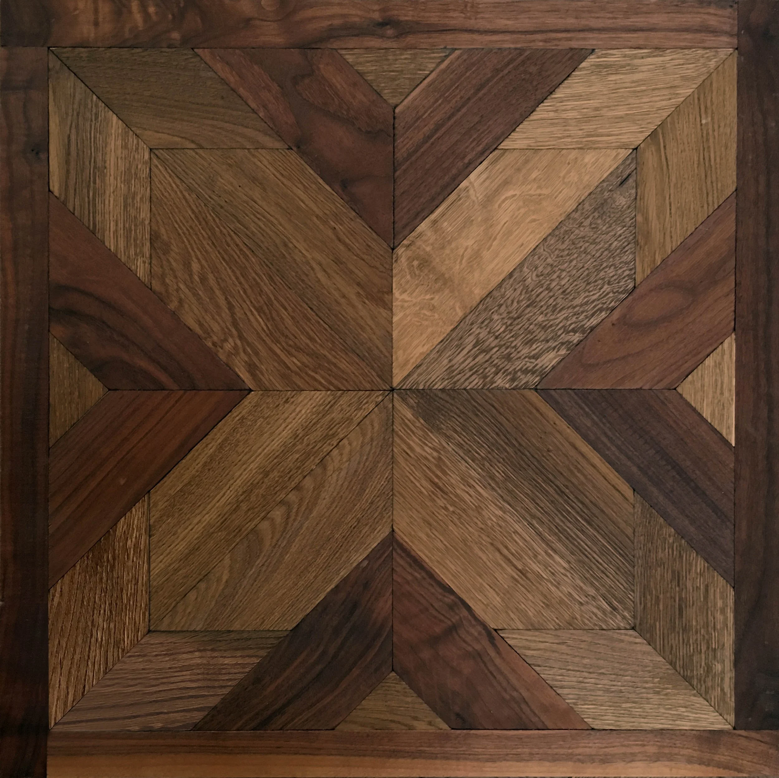 superficie de madera decorada con patrón geométrico en tonos marrones y diferentes texturas.