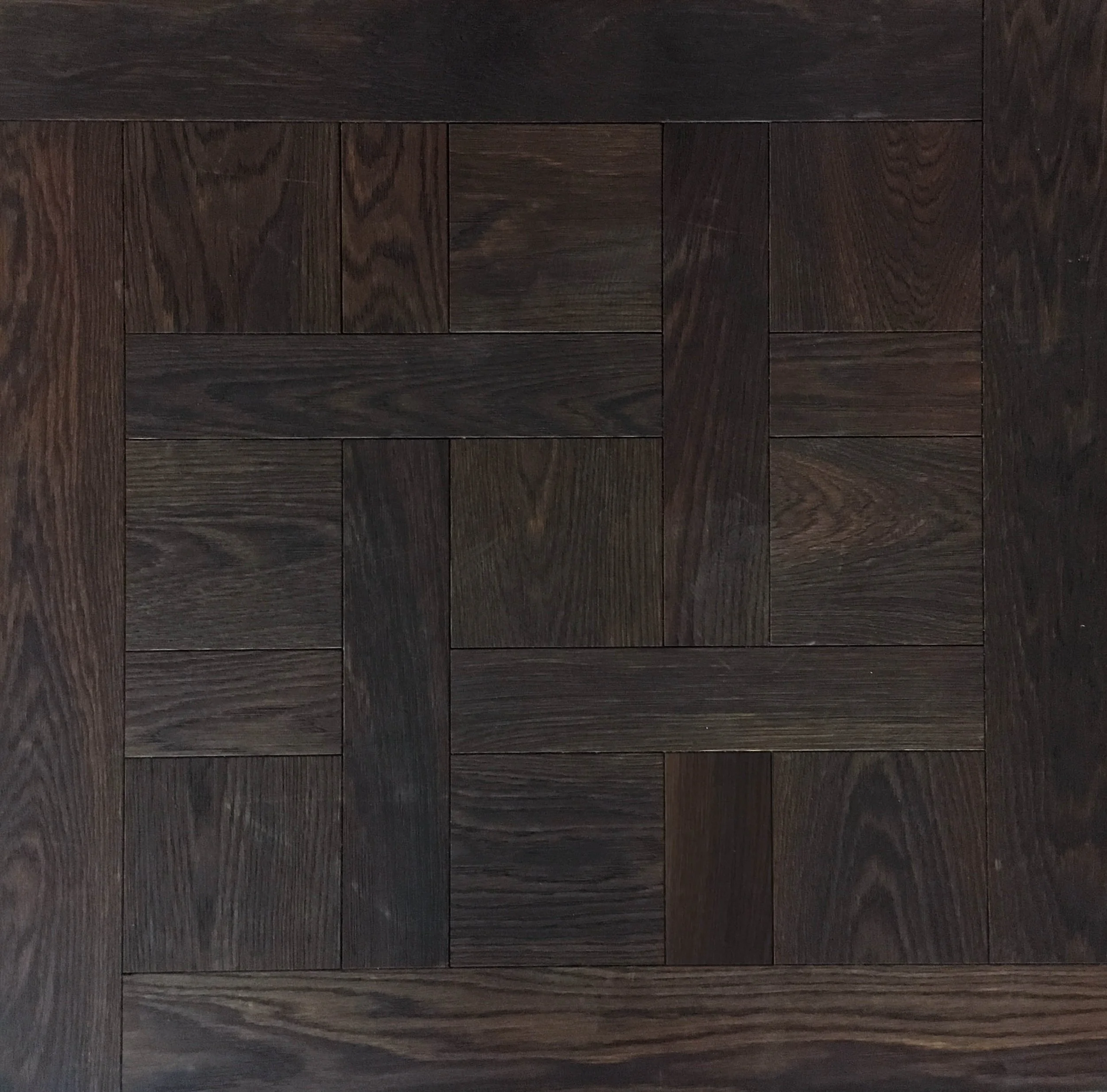 Suelo de madera oscura en patrón cuadrado con diferentes tonos y vetas.