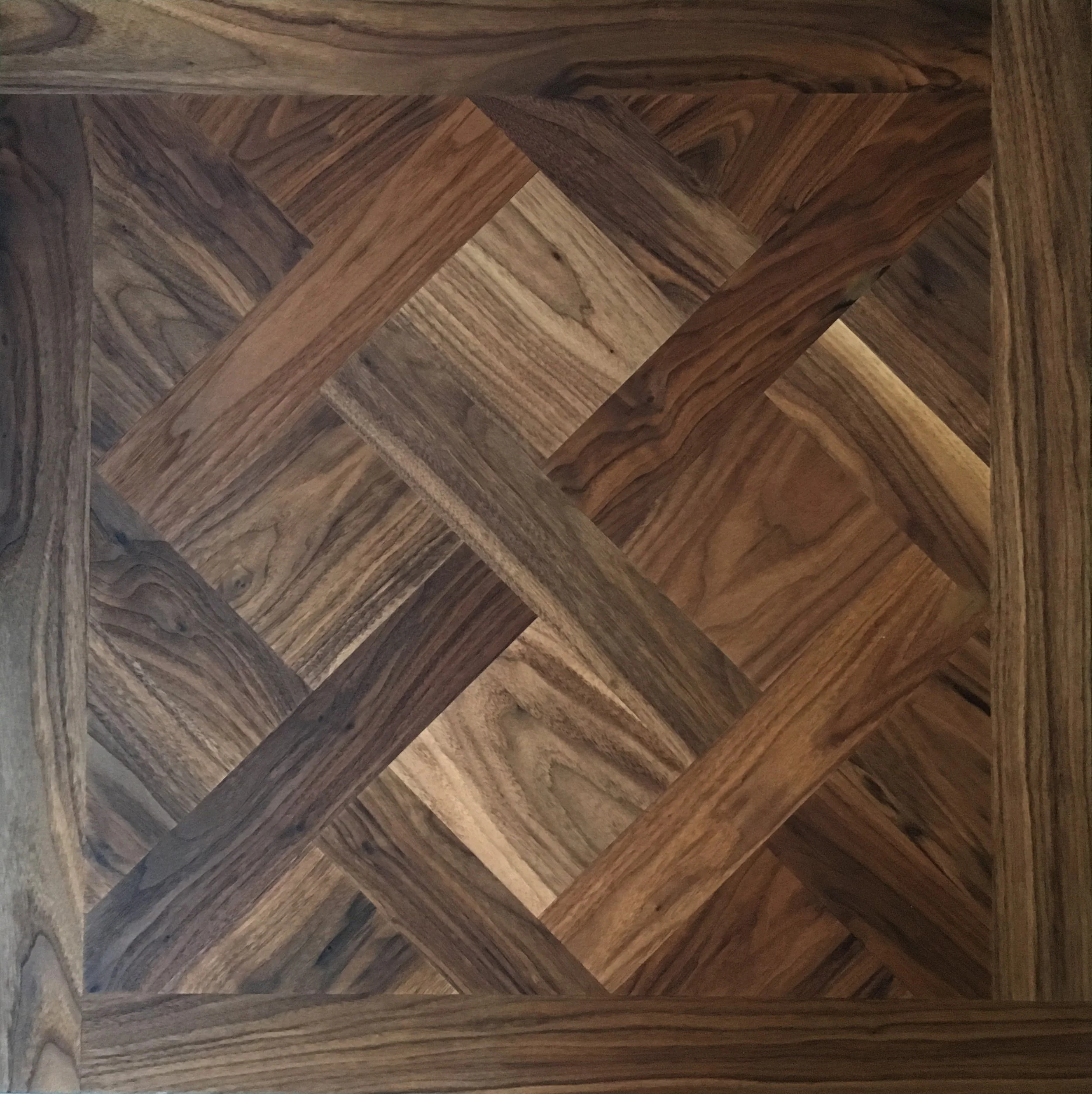 Detalles de un patrón de madera en tonos marrones, formando un diseño entrelazado en un piso o superficie.