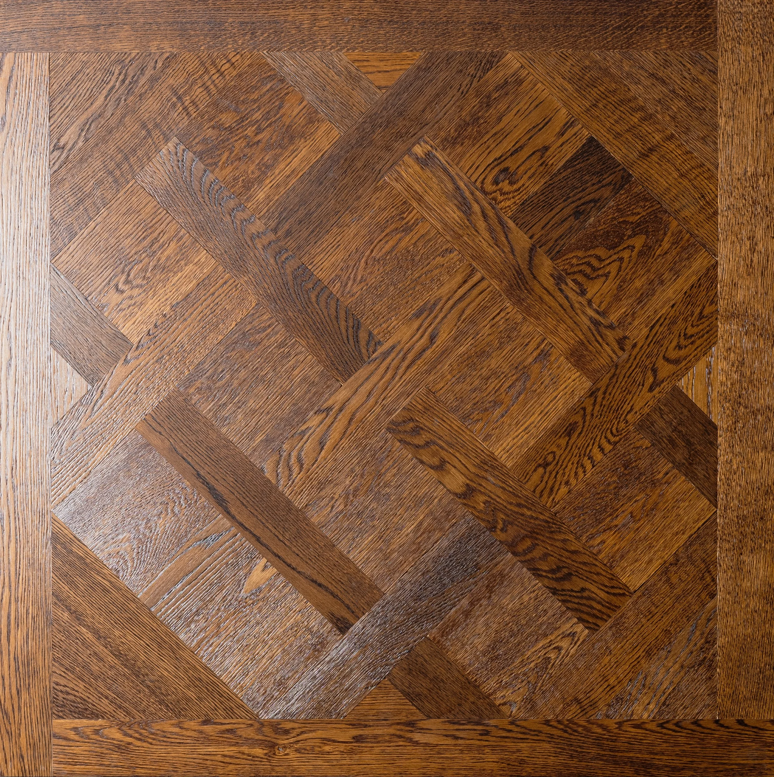 Superficie de madera con un patrón de parquet en forma de rombo.