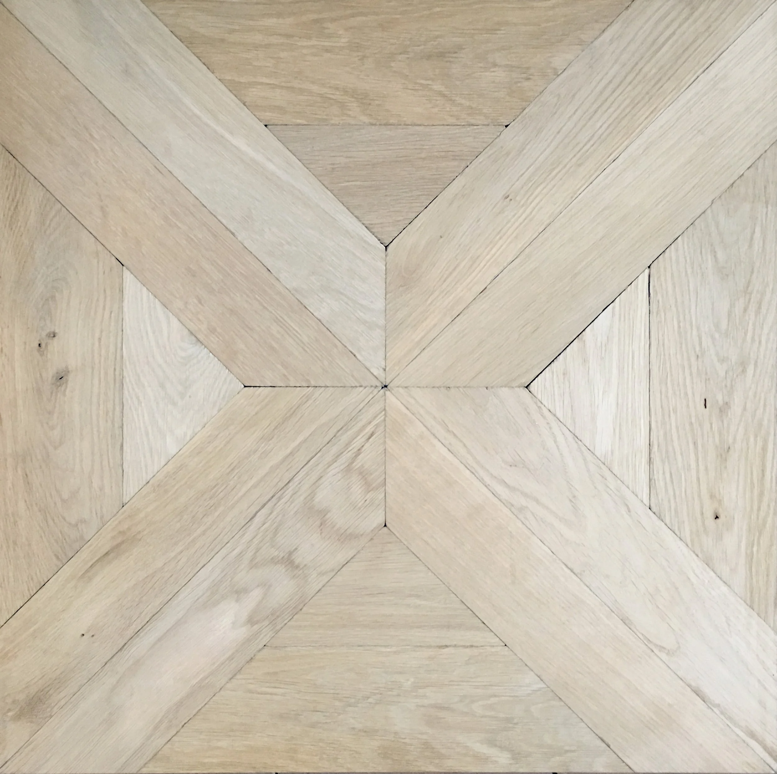 Suelo de madera con patrón en forma de 'X' y detalles diagonales en tonos claros.