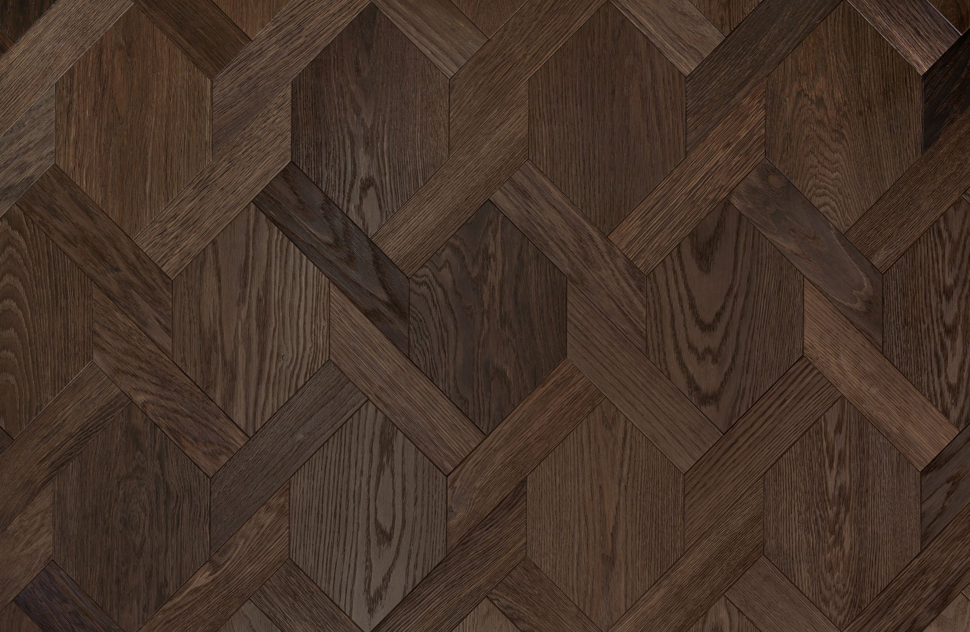 Superficie de piso de madera con patrón en forma de hexágonos y líneas entrelazadas en tonos marrón.